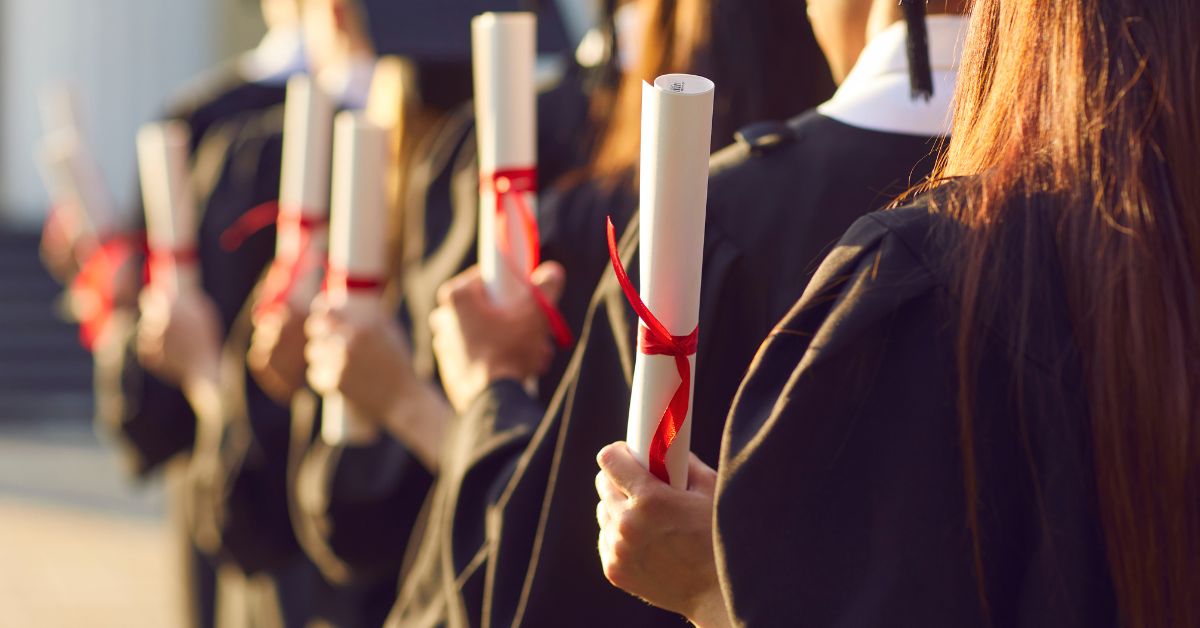 Students holding up diplomas at a valedictory
