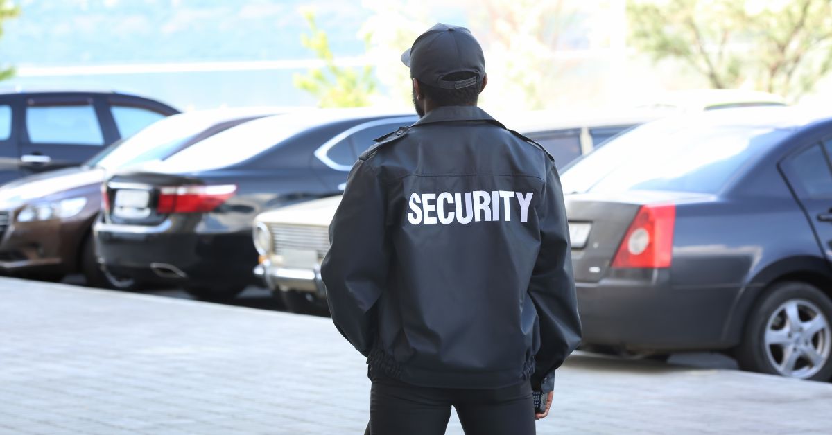 tipping in south africa - A car guard watching cars with the word Security on his back