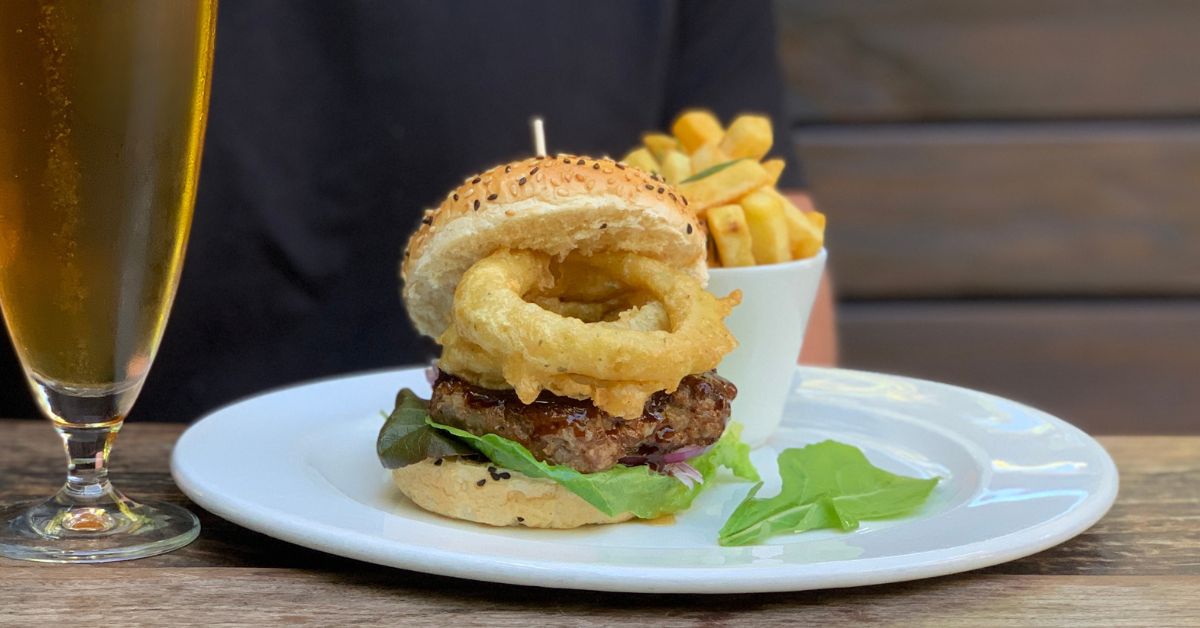 windhoek draught and a Forries burger and chips on a table