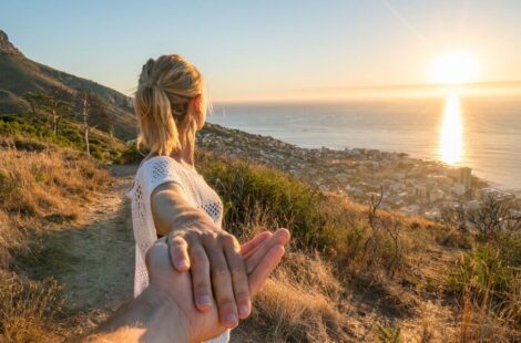 places to visit in cape town for couples feature image - lady looking at a sunset and devils peak with her hand holding her partners