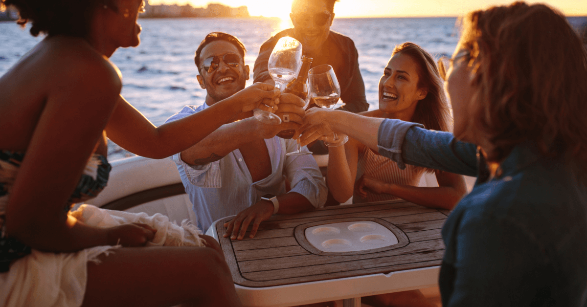 Group of Colleagues toasting their glasses while on a Catamaran at sunset in Cape Town 